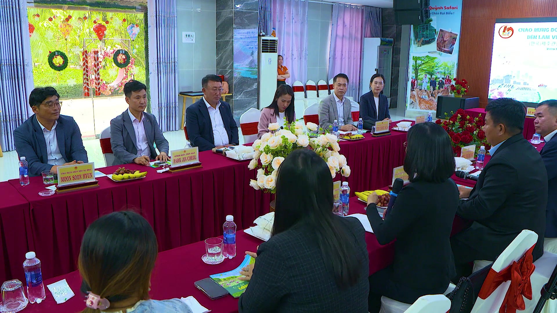 Khu hội nghị – hội thảo: phòng họp với bàn tiệc trải khăn đỏ, màn hình trình chiếu và đại biểu