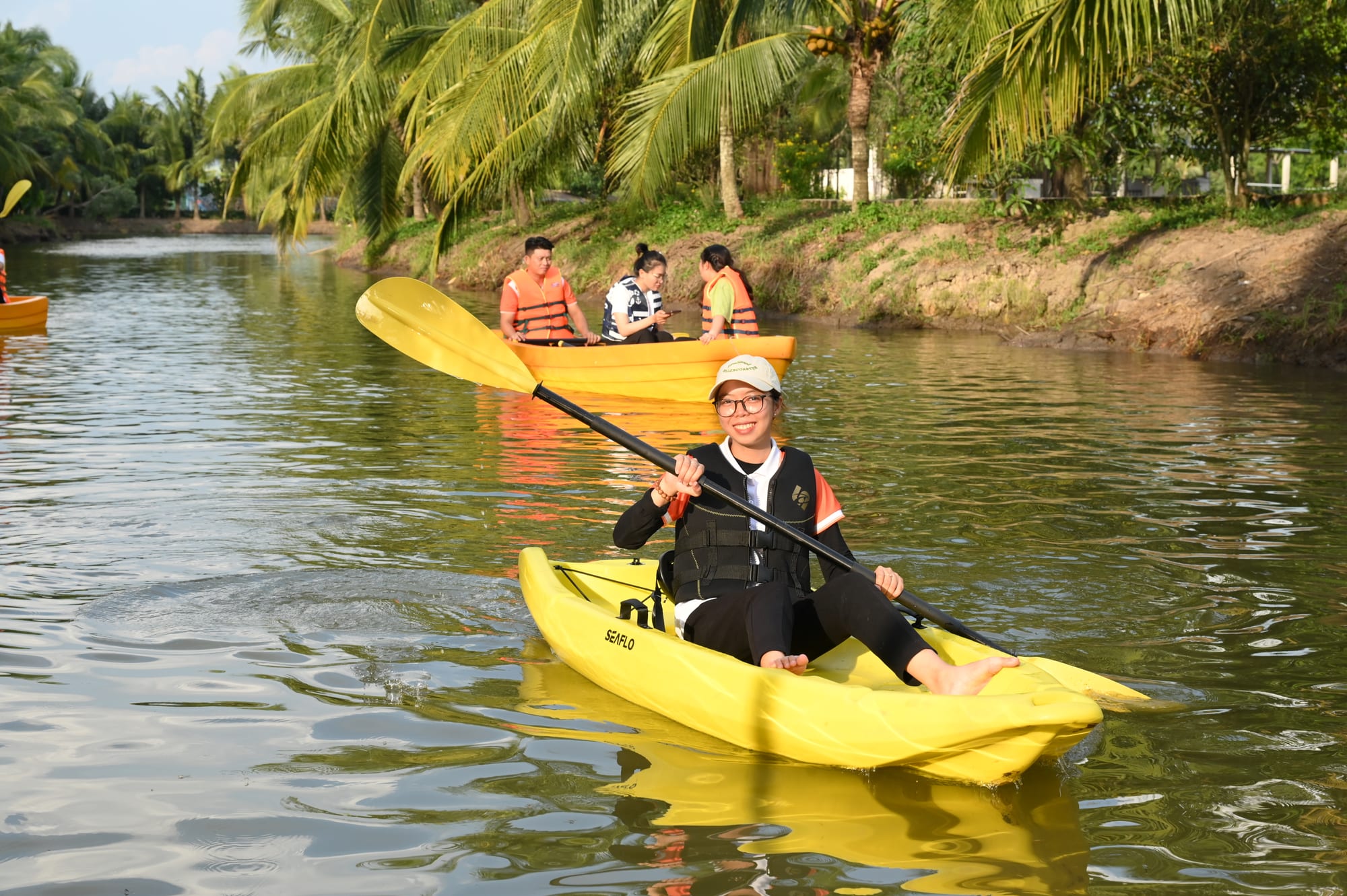 Du khách chèo thuyền kayak vàng trên kênh nước