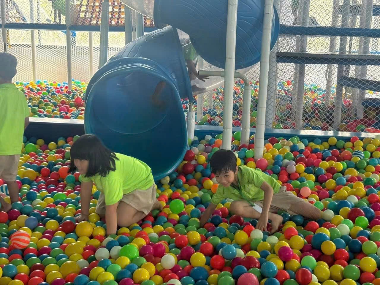 Trẻ em chơi trong hồ bóng và cầu trượt ở khu vui chơi trong nhà